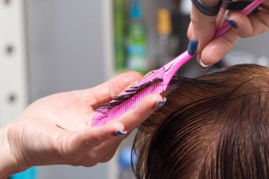 Güzellik salonunda makas kesen bir kadın.