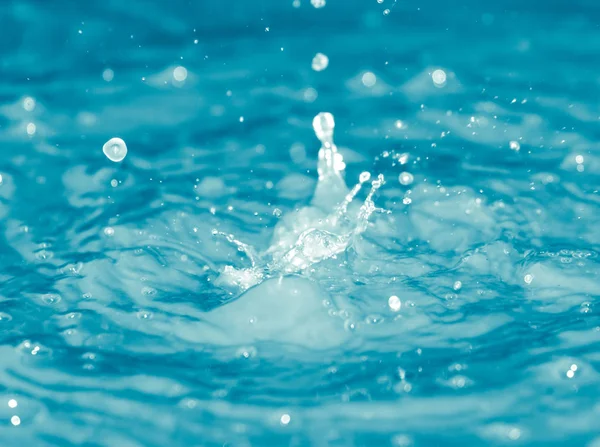 Gotas de água caindo na água azul — Fotografia de Stock