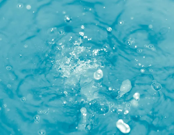 Drops of water falling into blue water — Stock Photo, Image