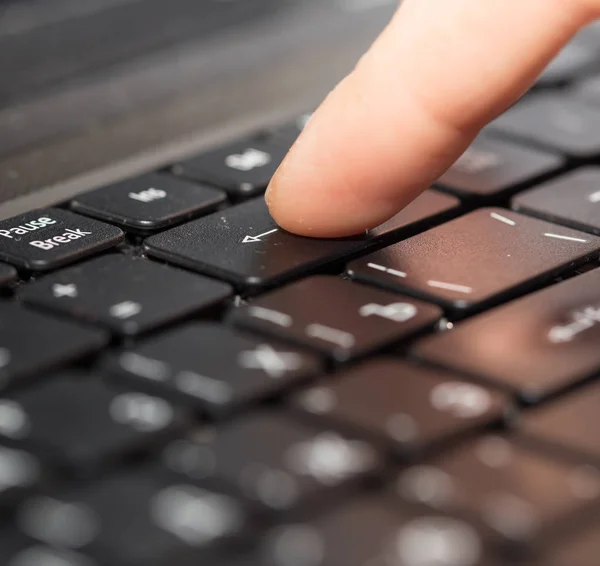 Bir dizüstü bilgisayar klavye üzerinde parmak — Stok fotoğraf