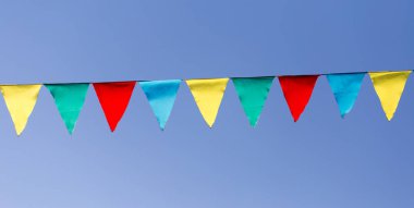 mavi gökyüzüne karşı çok renkli bayraklar