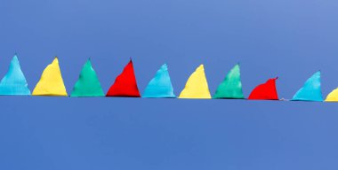 mavi gökyüzüne karşı çok renkli bayraklar