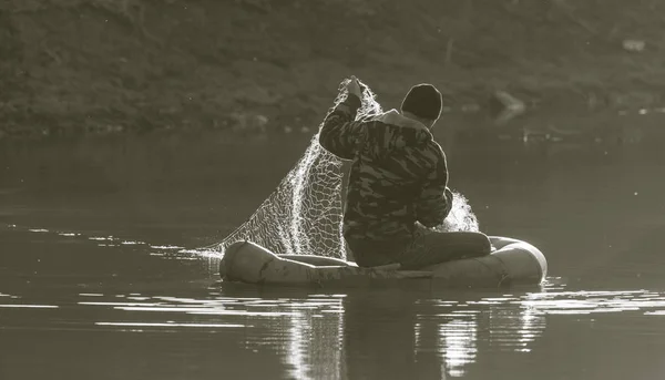 Pescador rede de pesca em um barco — Fotografia de Stock