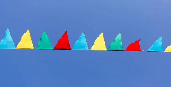 Bandeiras multicoloridas contra o céu azul — Fotografia de Stock