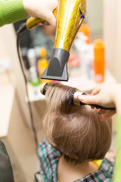 Cabeleireiro seca o cabelo loiro secador — Fotografia de Stock