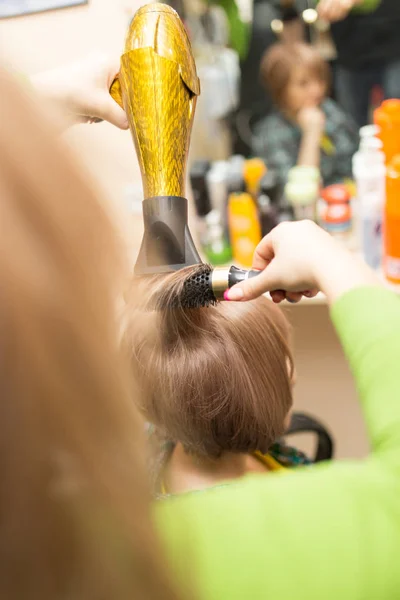 Cabeleireiro seca o cabelo loiro secador — Fotografia de Stock