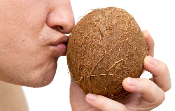 Um homem quer comer um coco em um fundo branco — Fotografia de Stock