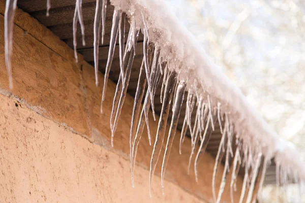 Παγοκρύσταλλοι σε μια στέγη ενός σπιτιού το χειμώνα — Φωτογραφία Αρχείου