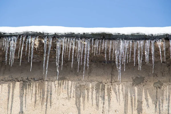 Icicles em um telhado de uma casa no inverno — Fotografia de Stock