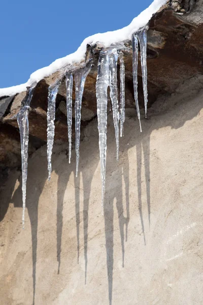 Los carámbanos sobre el techo de la casa en invierno —  Fotos de Stock