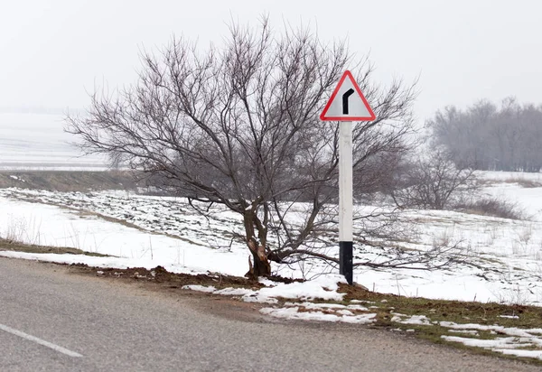 Teken op de asfalt weg op de natuur in de winter — Stockfoto