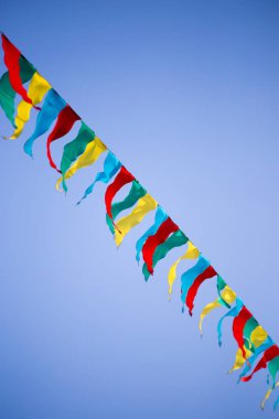 mavi gökyüzüne karşı çok renkli bayraklar