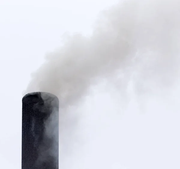 Fumaça de um tubo em um céu nublado — Fotografia de Stock