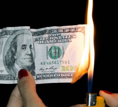 Siyah arka planda yanan 100 dolar.
