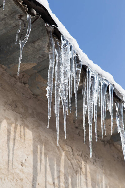 сосульки на крыше дома зимой
