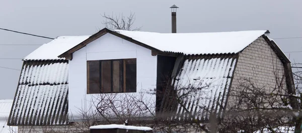Nieve en el techo de la casa en el invierno — Foto de Stock