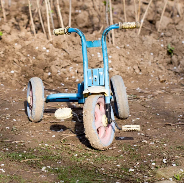 Oude childrens driewieler op aard — Stockfoto