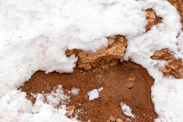 Neve em barro vermelho na natureza — Fotografia de Stock