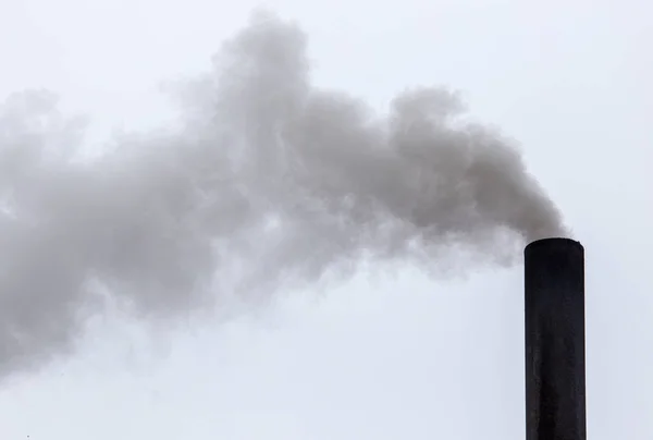 Smoke from a pipe on a cloudy sky — Stock Photo, Image