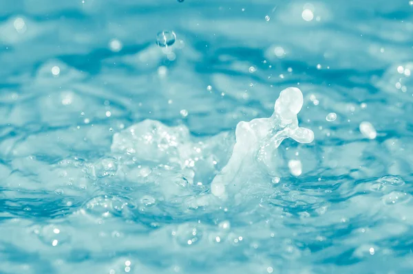 Gotas de agua cayendo en agua azul —  Fotos de Stock