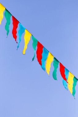 mavi gökyüzüne karşı çok renkli bayraklar