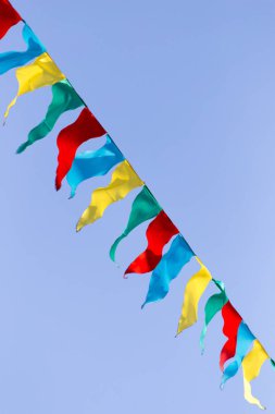 mavi gökyüzüne karşı çok renkli bayraklar