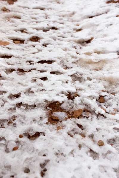 Schnee auf rotem Lehm in der Natur — Stockfoto