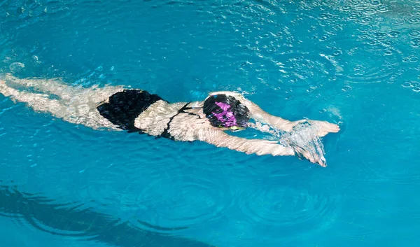 Meisje zwemmen in het zwembad — Stockfoto