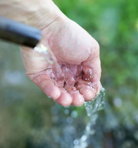 Hand i kranvatten i naturen — Stockfoto