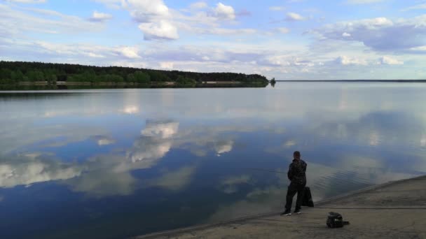 Záběry Osamělého Muže Stojícího Břehu Klidného Jezera Mraky Odrážejícími Vodní — Stock video