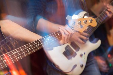 Agresif bir şekilde sahnede gitar çalıyor. Fotoğraflar stüdyoda.