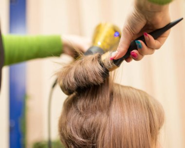 Kuaför saç kurutma makinesini kurutur. .