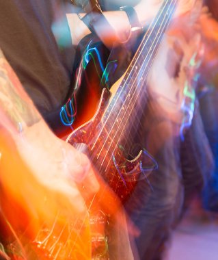 Agresif bir şekilde sahnede gitar çalıyor. Fotoğraflar stüdyoda.