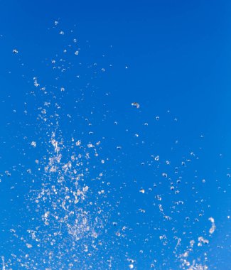 Çeşmeden akan su mavi gökyüzünün arka planında .