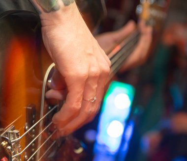 Agresif bir şekilde sahnede gitar çalıyor. Fotoğraflar stüdyoda.