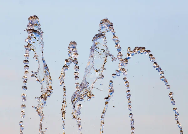 青い空を背景に噴水から水が飛び散る — ストック写真