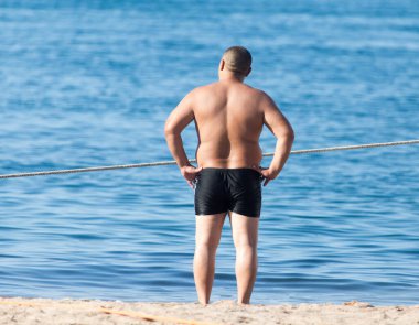 Sahilde mayo giymiş bir adam. .