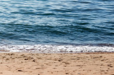 Denizin kumlu kıyısı bir zemin gibi .