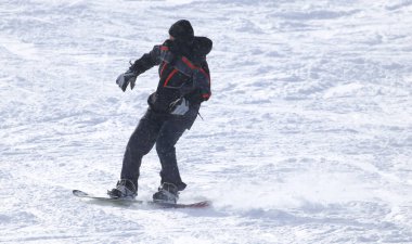 İnsanlar kışın karda snowboard yapıyor. .