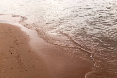 Denizin kumlu kıyısı bir zemin gibi .