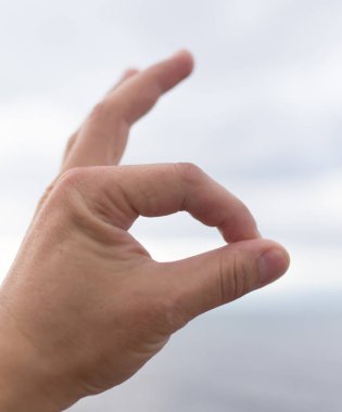 İnsanın eli denizin arka planında bulutlu. .