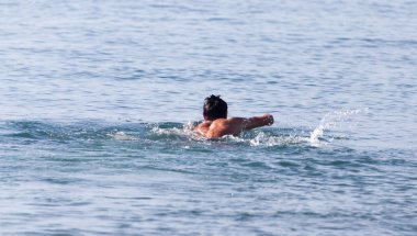 Adam sahildeki gölde banyo yapıyor. .