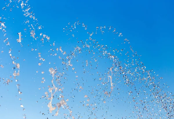 青い空を背景に噴水から水が飛び散る — ストック写真