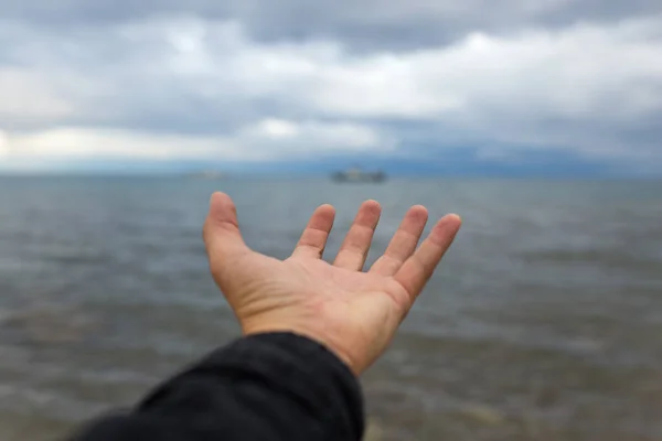 Hand Van Mens Een Achtergrond Van Zee Met Wolken — Stockfoto