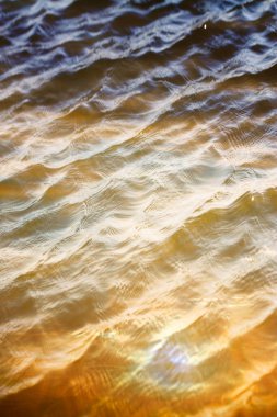 Gökyüzü ve bulutlar su yüzeyine dalga dalga yansıyor. .