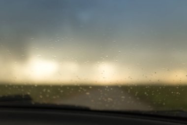 Arabanın ön camına yağmur damlaları. Doğadaki parkta.