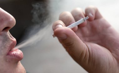 Adam sigara içiyor. Doğadaki parkta.
