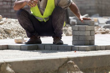 İşçi yola kaldırım taşı koyar .