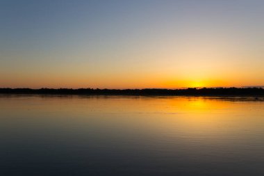 Nehirde güzel bir gün batımı. Doğadaki parkta.