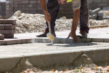 İşçi yola kaldırım taşı koyar .